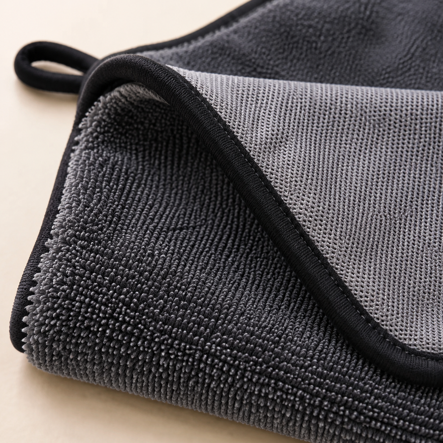 La microfibre bleue Kayore essuie une paroi de douche humide